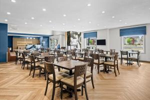 a dining room with tables and chairs at Home Inn & Suites Regina Airport in Regina
