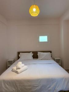 a white bed with a white towel on it at Aigialos Villas with Private Beach by Hospi Living in Ferma +73 photos