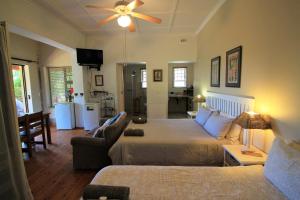 a bedroom with a bed and a living room at Dempsey's Self-Catering Guest House in Port Elizabeth