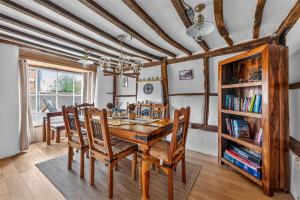 a dining room with a wooden table and chairs at Ye Olde Cottage in Crawley