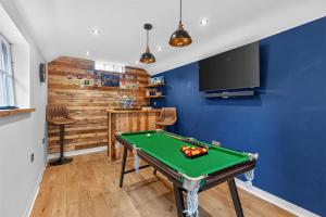 a pool table in a room with blue walls at Ye Olde Cottage in Crawley