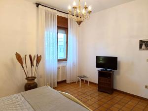 a bedroom with a bed and a flat screen tv at Dimora Giovanna in Poggiardo