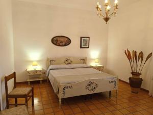 a bedroom with a bed and two tables and a chandelier at Dimora Giovanna in Poggiardo