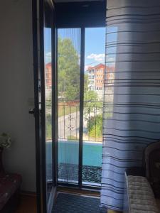 a sliding glass door with a view of a pool at Restful Garden Apartmants in Sarajevo