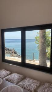 a view of the ocean from a bedroom window at Aigialos Villas with Private Beach by Hospi Living in Ferma
