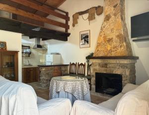a living room with a stone fireplace and a table at Casa El saucar in El Robledo