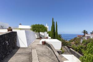 a walkway next to a white building and the ocean at Casa La Breña La Palma in Breña Baja