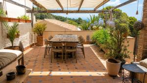 a patio with a table and chairs in a greenhouse at Casa Rural Gastronómica Cal Mian in Almoster