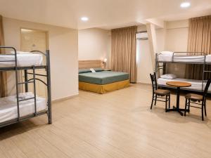 モンテレイにあるHotel Son- Mar Monterrey Centroの二段ベッドとテーブルと椅子のある寮の部屋 +21枚の写真