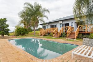 a swimming pool in front of a house at Ukholo Lodge in Citrusdal