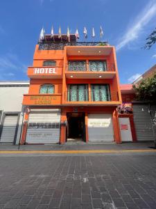 an orange building with a hotel on a street at Hotelito Lindo León in León