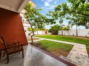 a bench sits on the porch of a house with a yard at Coastal Breeze Talalla in Talalla South