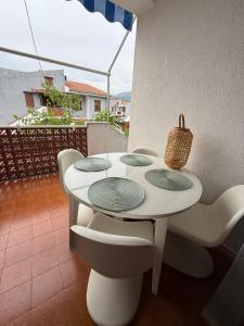 a white table and chairs on a balcony at Casa Anneli - Scalea Park 2000 in Scalea
