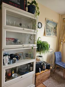 a white hutch filled with lots of pots and pans at Quiet room near everything in a shared apartment in Helsinki
