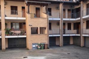 an apartment building with two trash cans in the courtyard at Oasi Bernareggio Smart Work & Relax in Bernareggio