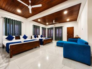 a large room with two beds and blue chairs at Coastal Breeze Talalla in Talalla South