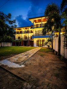 a building with palm trees in front of it at Coastal Breeze Talalla in Talalla South