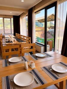 a dining room with a table with white plates on it at Hotel Gold Kazbegi in Kazbegi