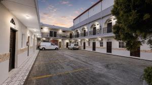 a building with two vans parked in a parking lot at Hotel King del Centro San Miguel in San Miguel