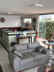 a living room with a couch in front of a kitchen at Hotel Coqueiral in Recife