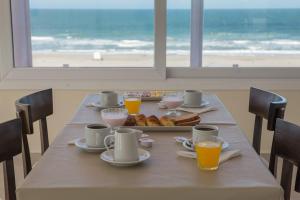 una mesa con una bandeja de comida con vistas a la playa en Sul Mare Hotel en Valeria del Mar