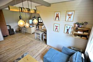 a living room with a blue couch and some pictures on the wall at PrzyTuLasek - domek pod lasem w sercu natury, blisko Energylandii in Zator