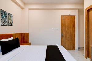 a bedroom with a bed and a wooden door at Hotel O NamaStay in kolkata +30 photos