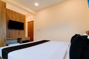 a bedroom with a bed and a flat screen tv at Hotel O NamaStay in kolkata