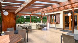 an outdoor patio with tables and chairs and windows at Hotel Slezská in Muglinov