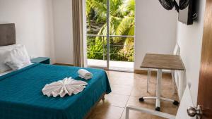 a bedroom with a bed and a table and a window at HOTEL NATIVOS in La Vega