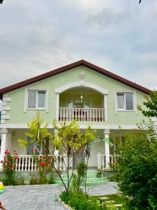a green house with a balcony and flowers at Green House in Dilijan