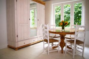 a dining room with a table and chairs and windows at Suite im Huus in Hamburg