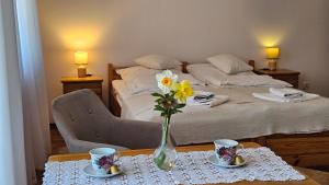 a bedroom with a bed with a vase of flowers on a table at Pensjonat Fluder in Jaszczurowa