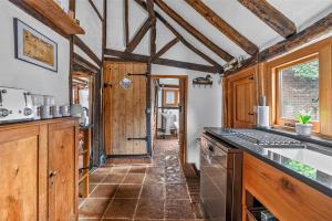 a kitchen with wooden cabinets and a counter top at Ye Olde Cottage in Crawley