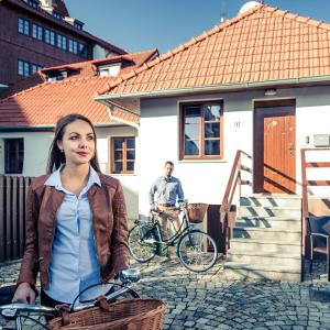 Une fille debout avec un vélo devant une maison dans l'établissement Luxury Apartments No. 91, à Český Krumlov