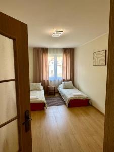 a room with two beds and a window at Nad Wadągiem in Kieźliny +3 photos