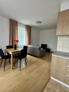a living room with a table and a couch at Nad Wadągiem in Kieźliny