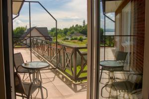 a balcony with two tables and chairs and a view at Manor 2 in Stará Lesná