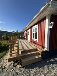 a wooden deck on the side of a house at Tiny House with ocean view in Näs