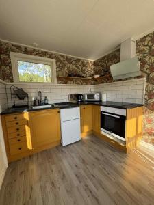 a kitchen with yellow and white appliances in a room at Tiny House with ocean view in Näs +6 photos