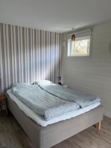 a bedroom with a large bed with a window at Tiny House with ocean view in Näs