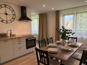 a kitchen with a table with chairs and a clock on the wall at Manor 2 in Stará Lesná