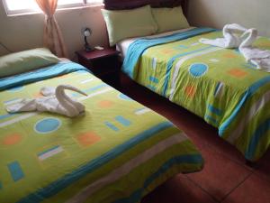 two beds sitting next to each other in a bedroom at Hostal Miconia in Puerto Ayora