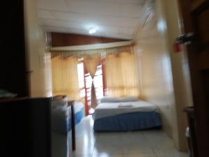 a small room with a bed and a window at Hostal Miconia in Puerto Ayora