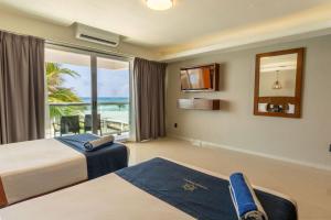ein Schlafzimmer mit zwei Betten und Meerblick in der Unterkunft Ocean Dream Cancun by GuruHotel in Cancún + 106 Fotos