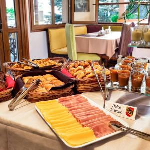 a table with cheese and bread and other foods at Berna Hotel & Spa in Villa General Belgrano