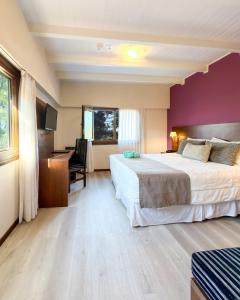 a hotel room with a large bed and a desk at Berna Hotel & Spa in Villa General Belgrano