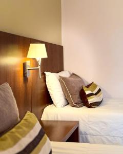 a hotel room with two beds and a lamp at Berna Hotel & Spa in Villa General Belgrano +30 photos
