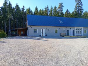 a large white barn with a blue roof at Seeblickwohnung Aäng 6 Pool, Billard in Mjöhult
