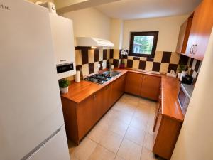 a kitchen with brown cabinets and black and white tiles at Vila Monica in Buşteni +14 photos